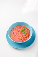 Tomato gazpacho soup in blue bowl.