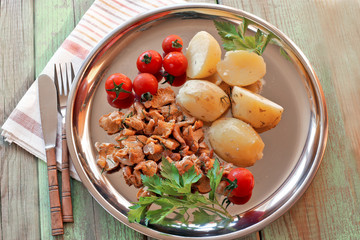 Fried chanterelles with potato and tomatoes cherries
