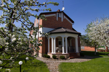 Very pretty house made of red bricks, surrounded with gorgeous trees