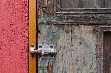 English lock at the wooden rustic door and red wall