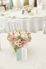 Fototapeta na wymiar Menu card with beautiful flowers on table in wedding day