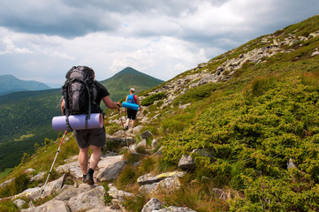 Group of tourists with large backpacks are on mountain