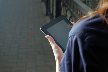 Redhead business women holding tablet pc in her arms. Blank