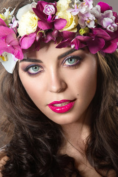 Beautiful girl with perfect skin and bright floral wreath on her head