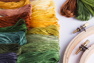 Embroidery yarns and hoops on fabric background