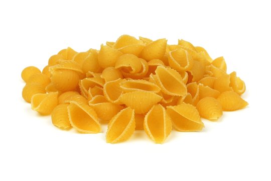 Pile of uncooked dry shell pasta isolated on a white background