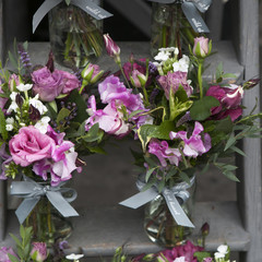 bouquet of Sweet pea, Lathyrus odoratus, flowers in a purple vase standing on wooden grey steps