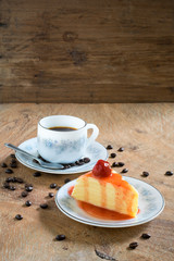 Strawberry crepe cake and a cup of coffee on wooden background