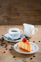 Strawberry crepe cake and a cup of coffee on wooden background