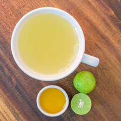 Cup of tea with honey and lemon on wooden table