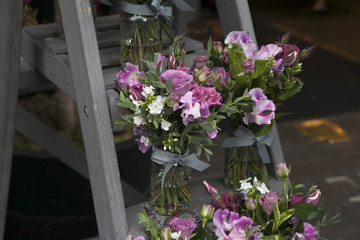 bouquet of Sweet pea, Lathyrus odoratus, flowers in a purple vase standing on wooden grey steps