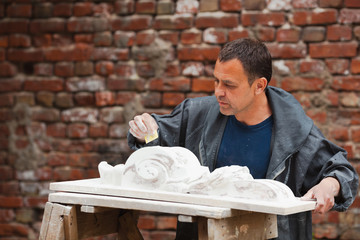 craftsman restorer working with gypsum model