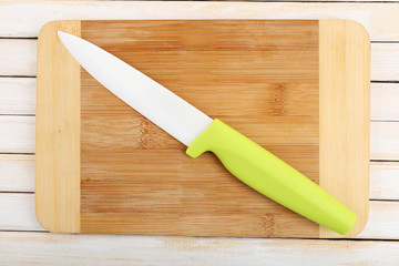 Kitchen knife and cutting board on wooden table