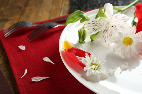 Tableware with flowers on table close up