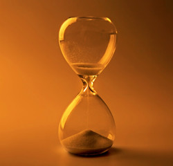 Hourglass on color background