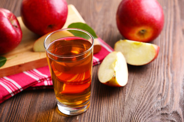 Glass of apple juice and fruits on table close up