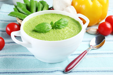 Tasty peas soup and vegetables on table close up