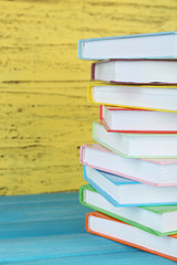 Stack books on yellow wooden background
