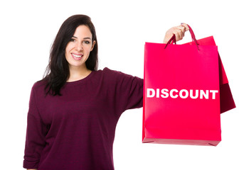 Caucasian woman show with shopping bag and showing a word discou