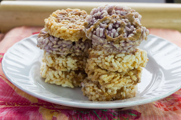 Thai dessert Khanom Nang Let, a round and flat sweetmeat made from fried dried rice and topping with sugar cane