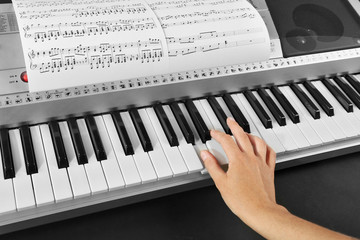 Woman playing synthesizer close up