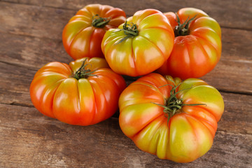 Green tomatoes on wooden table close up