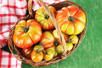 Green tomatoes in basket on table close up