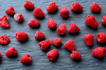 Red sweet raspberries on wooden table close up