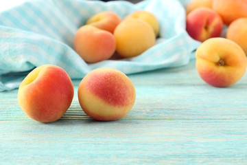 Ripe apricots with napkin on wooden table close up