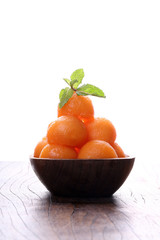 Organic cantaloupe melon in wooden bowl isolated on white backgr