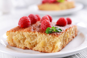 Fresh pie with raspberry in white plate on wooden table, closeup