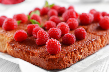 Fresh pie with raspberry on wooden table, closeup