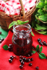 Jar of gooseberry jam on wooden table close-up