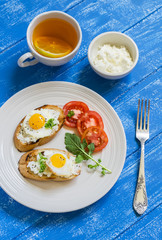 toast with soft feta cheese and quail eggs - a healthy Breakfast or snack, on blue wooden surface