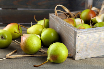 Ripe pears in wooden box on table close up