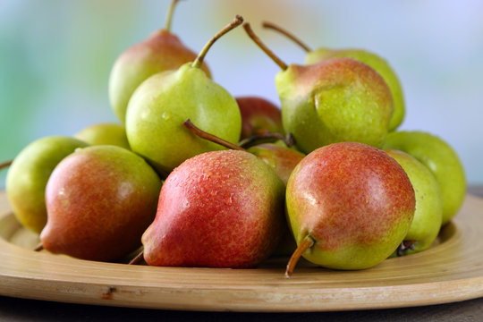 Ripe tasty pears on bright background