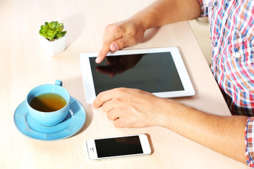 Man with digital tablet on wooden table background