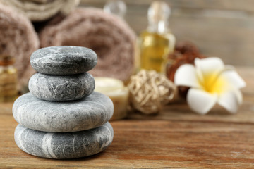 Stack of spa stones  and spa treatment on wooden background