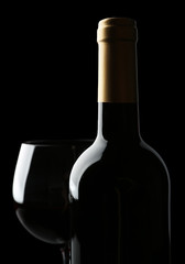 Bottle and glass of wine isolated on black