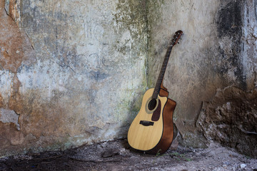 Guitar standing on the floor in a ruined houseю