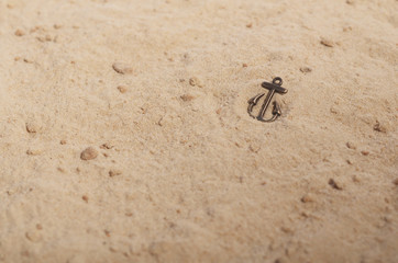 Bronze anchor on the yellow sand
