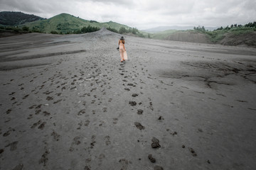 Female traveler walking near mud volcanoes
