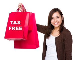 Asian woman holding with shopping bag and showing tax free