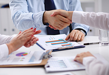 Business people handshake, sitting at the table