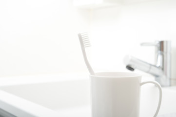 Fototapeta na wymiar 洗面台に置かれた歯ブラシとコップ