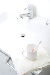 洗面台に置かれた歯ブラシとコップ