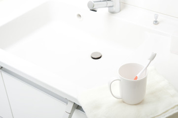 洗面台に置かれた歯ブラシとコップ