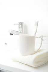 Fototapeta na wymiar 洗面台に置かれた歯ブラシとコップ