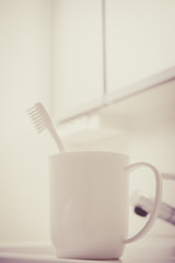 洗面台に置かれた歯ブラシとコップ