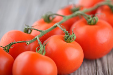 Tomatos on old wood background. Healthy and tasty food